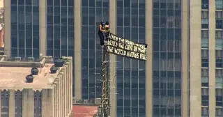 Pair scales Empire State Building for peace banner, kiss and mock proposal