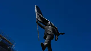 Banksy claims London statue: man blinded by flag strides off its plinth
