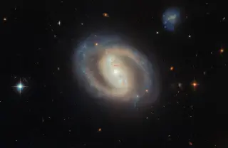 Hubble captures a glowing barred spiral galaxy with a blazing nucleus